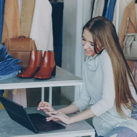 Dueña de una tienda de ropa revisando sus cuentas en el portátil